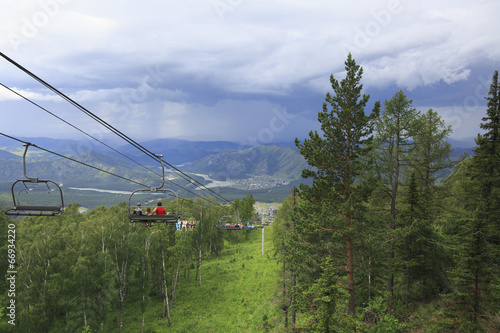 Tourists at the ski lift on a background of thunderclouds in the