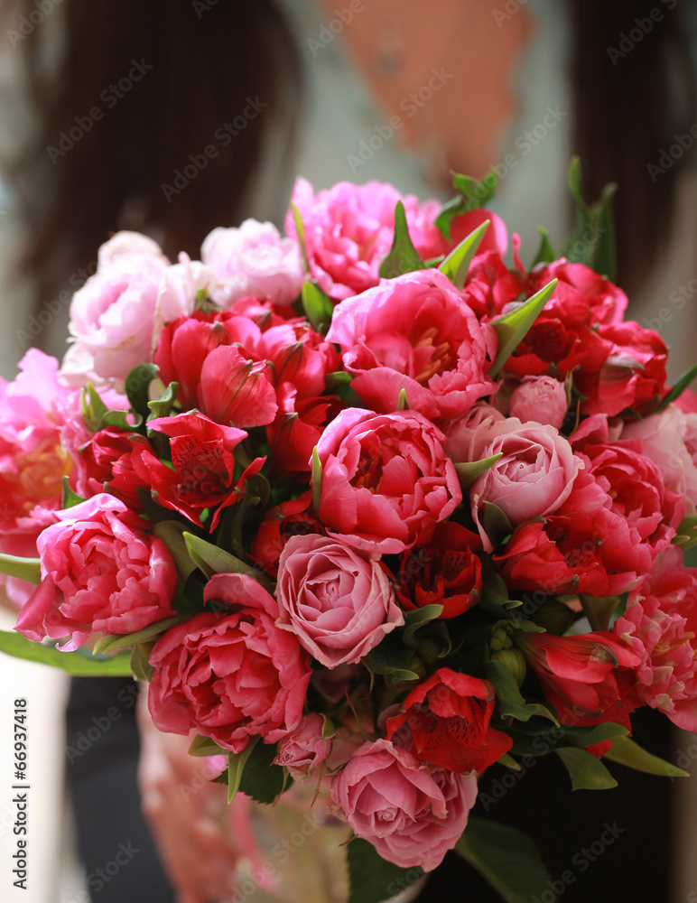 Obraz premium bouquet of red flowers of different colors in the hands of the g