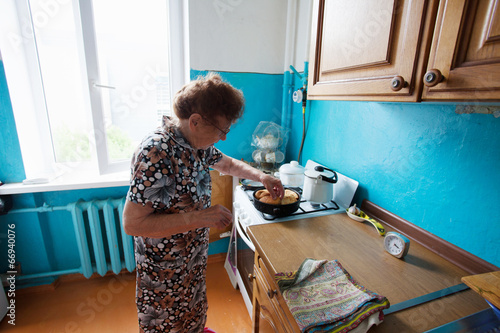 Elderly woman on the kitchen photo