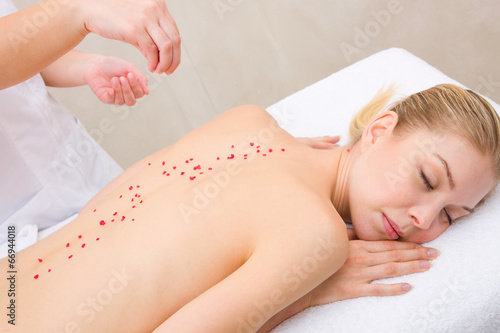Woman receiving massage with salt crystals spa