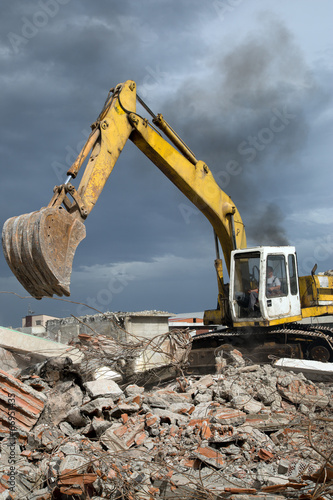 Bulldozer removes the debris from demolition of old buildings