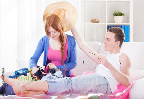 Young couple unpacking luggage and relaxing