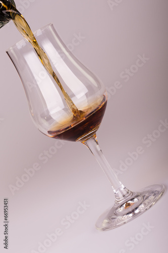 alcohol drink pouring into glass isolated on white background