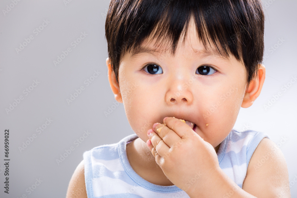 Asian baby boy eat cookie close up Asian baby boy eat cookie close up