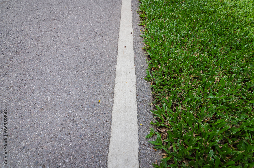 asphalt road with strip line and green grass
