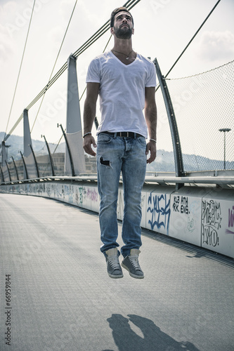 Canvas-taulu Handsome young man levitating in mid-air outdoors