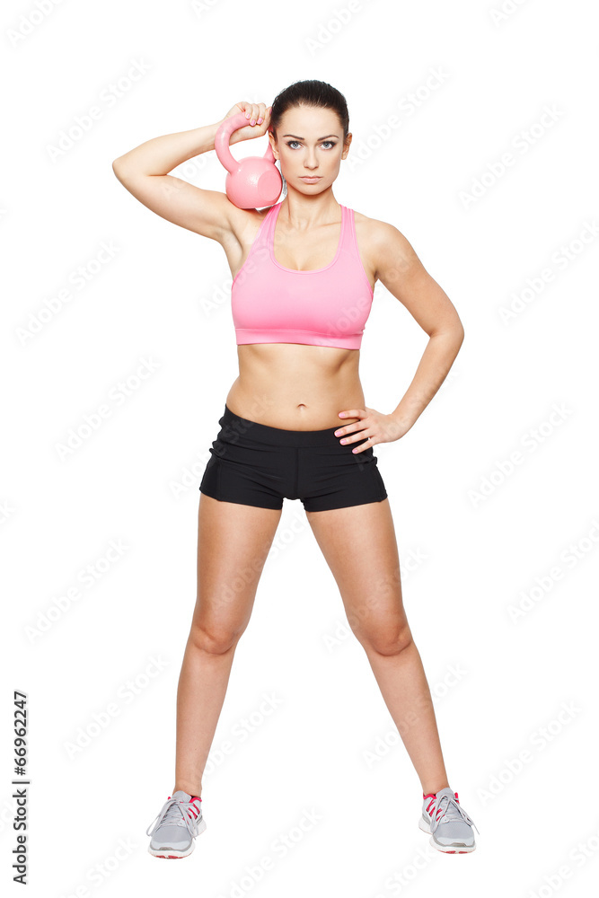 Fit woman holding kettlebell at neck Fit woman holding kettlebell at neck