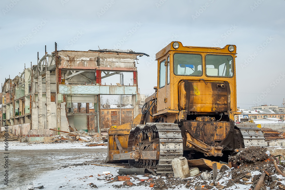 Bulldozer in front of old industrial building Bulldozer in front of old industrial building