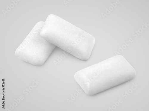 Three pieces of white chewing gums on gray with clipping path photo