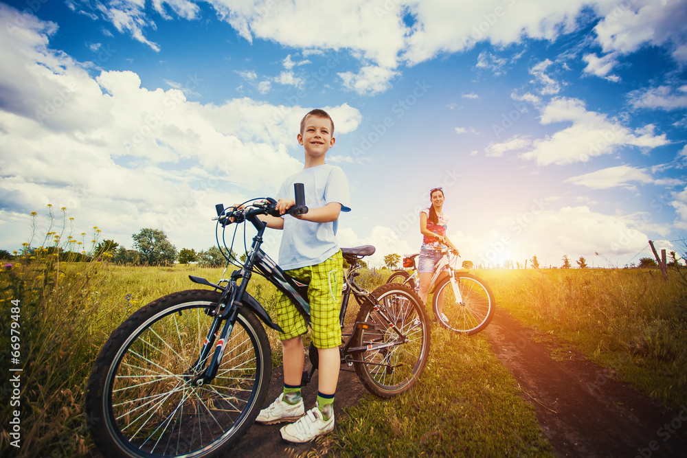 Obraz premium mother and son riding bicycle in the field