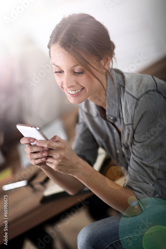 Young woman in training class sending text message