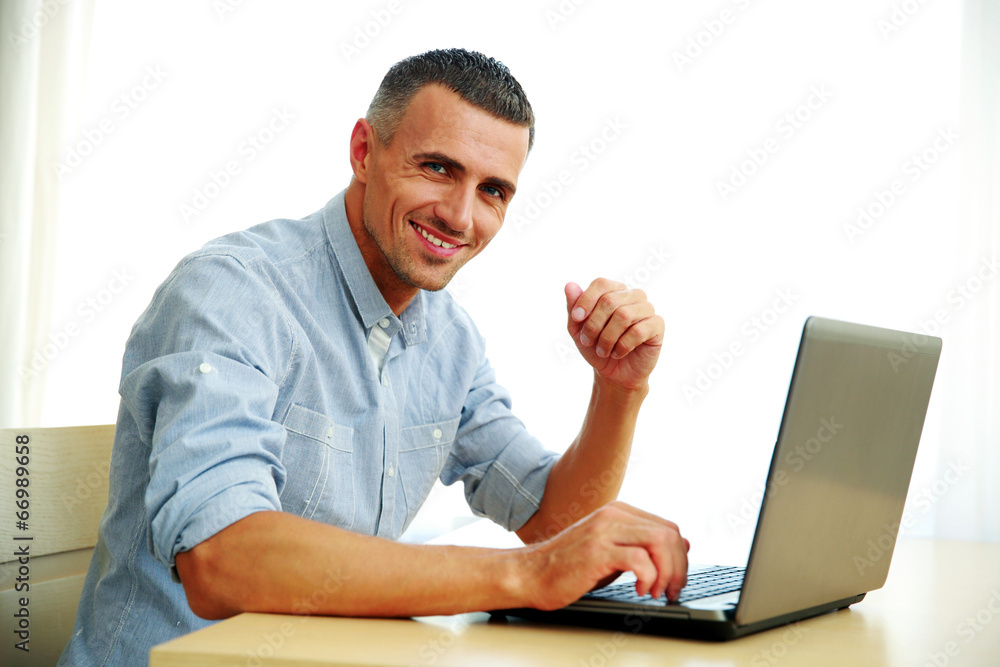 Handsome happy businessman working with laptop Handsome happy businessman working with laptop