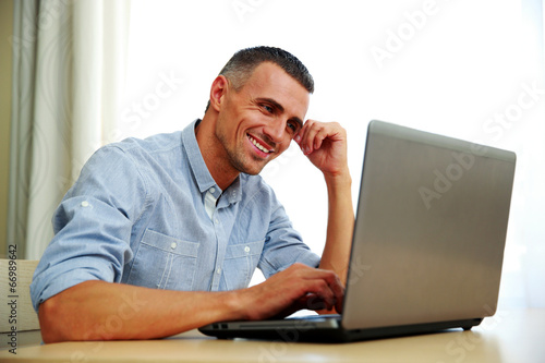 Smiling businessman working with laptop