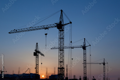Quadro em tela Silhouettes of construction cranes
