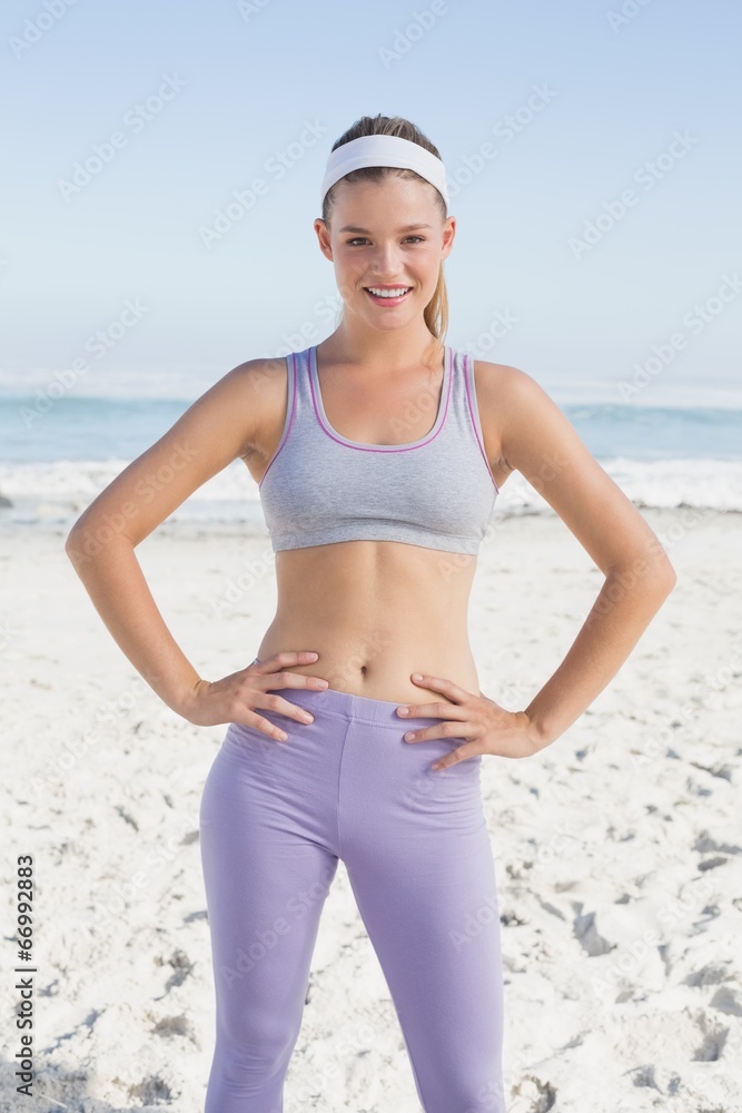 Sporty blonde on the beach smiling at camera Sporty blonde on the beach smiling at camera