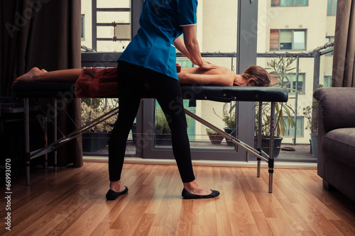 Massage therapist treating patient at home photo