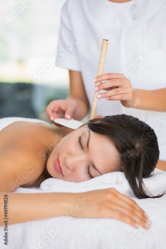 Relaxed brunette getting an ear candling treatment