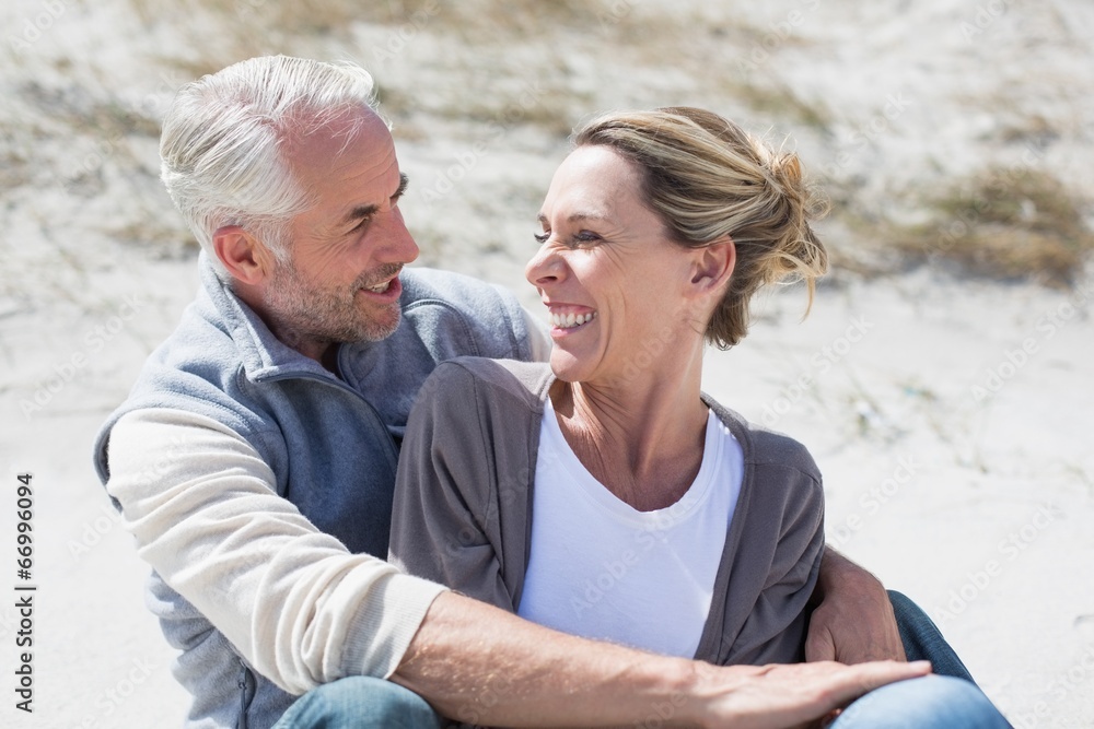 Attractive couple smiling at each other on the beach Attractive couple smiling at each other on the beach