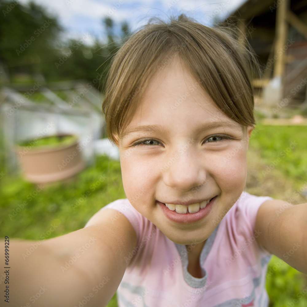 Funny little girl taking self portrait (selfie) outdoors. Funny little girl taking self portrait (selfie) outdoors.
