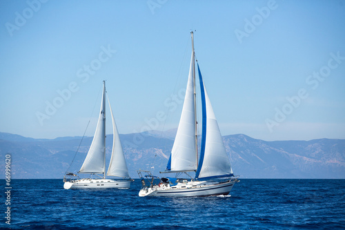 Group of sail yachts in regatta near a coast. © De Visu
