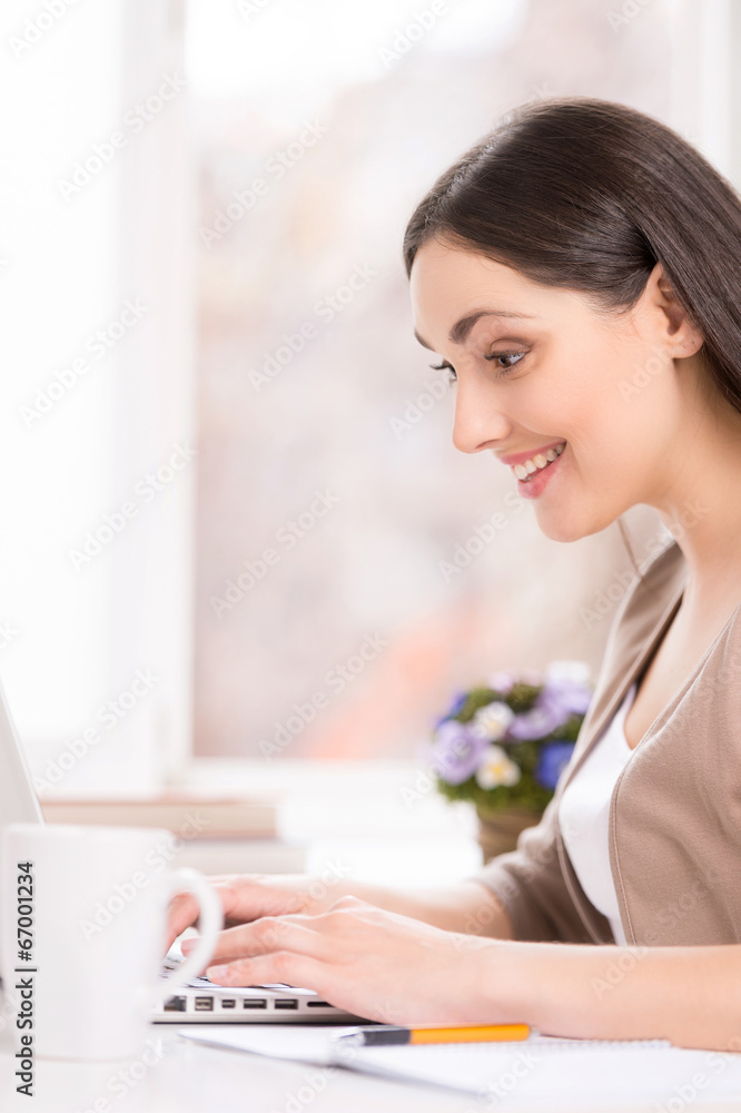 beautiful brunette sitting at desk and smiling. beautiful brunette sitting at desk and smiling.
