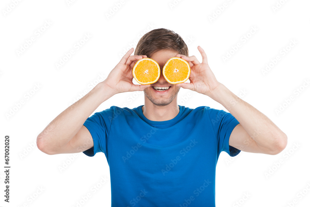 young man holding two oranges. young man holding two oranges.