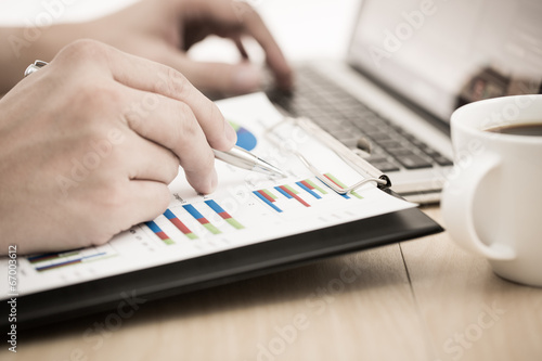 Businessman analyzing investment charts with laptop