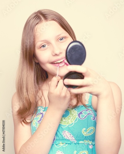 Happy teen girl holding mirror
