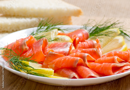 Sliced salted salmon served with lemon