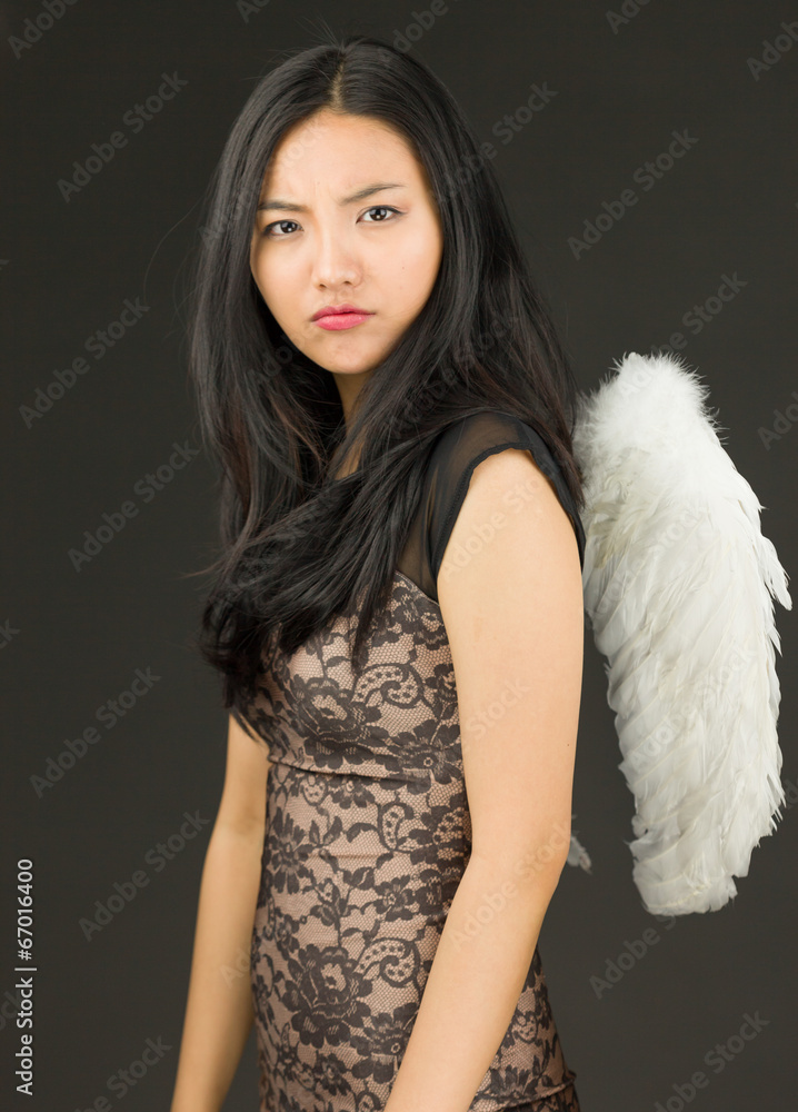 Serious Asian young woman dressed up as an angel Serious Asian young woman dressed up as an angel