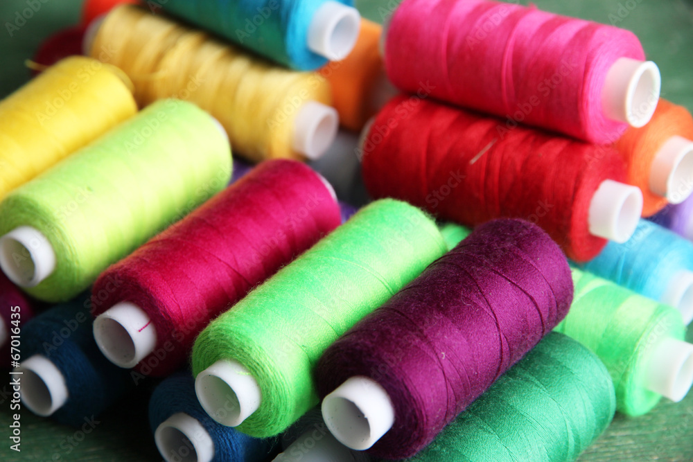 Multicolor sewing threads on wooden background Multicolor sewing threads on wooden background