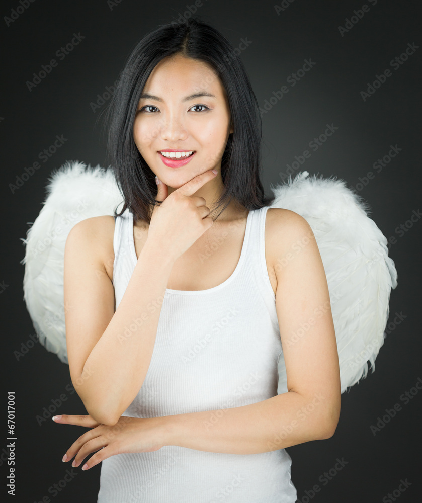 Asian young woman dressed up as an angel with hand on chin and Asian young woman dressed up as an angel with hand on chin and
