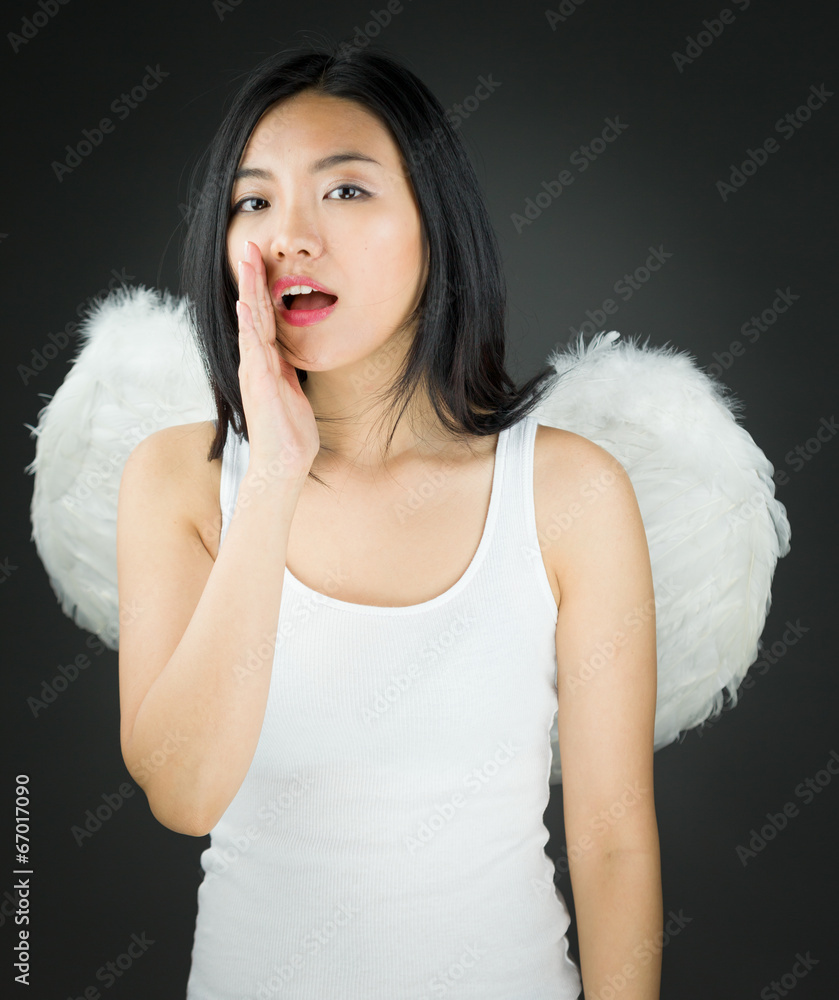 Asian young woman dressed up as an angel whispering Asian young woman dressed up as an angel whispering