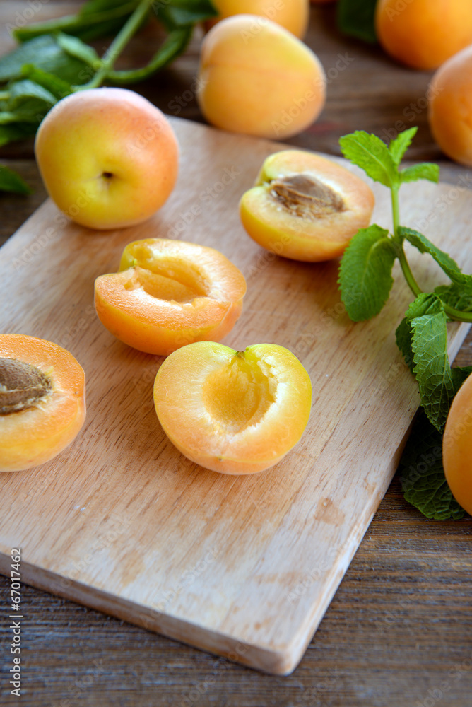 Ripe apricots with green mint leaves