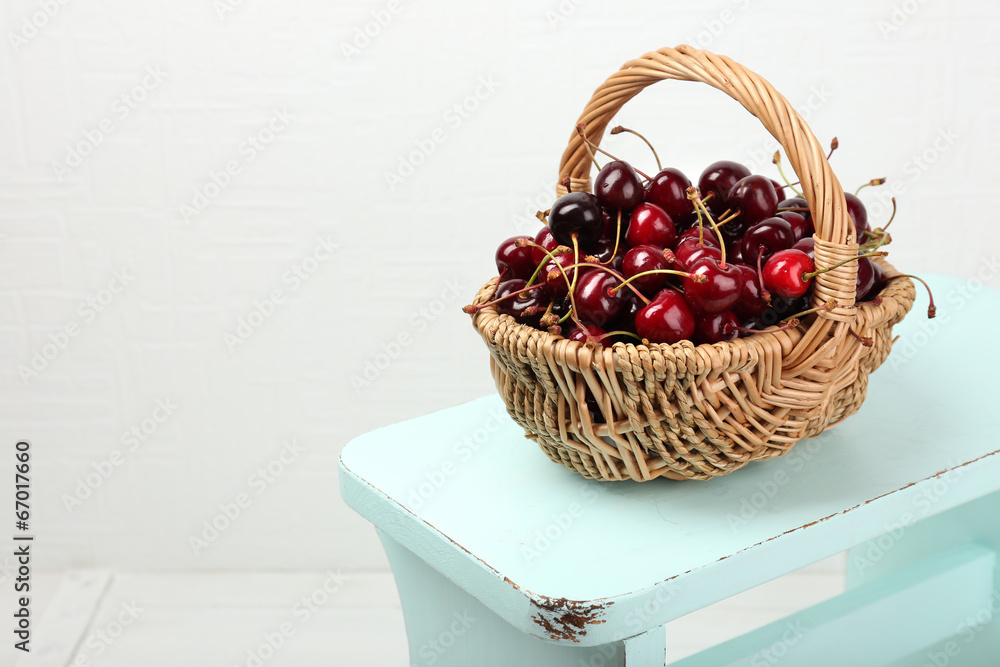 Fresh cherries in basket on white wall background Fresh cherries in basket on white wall background