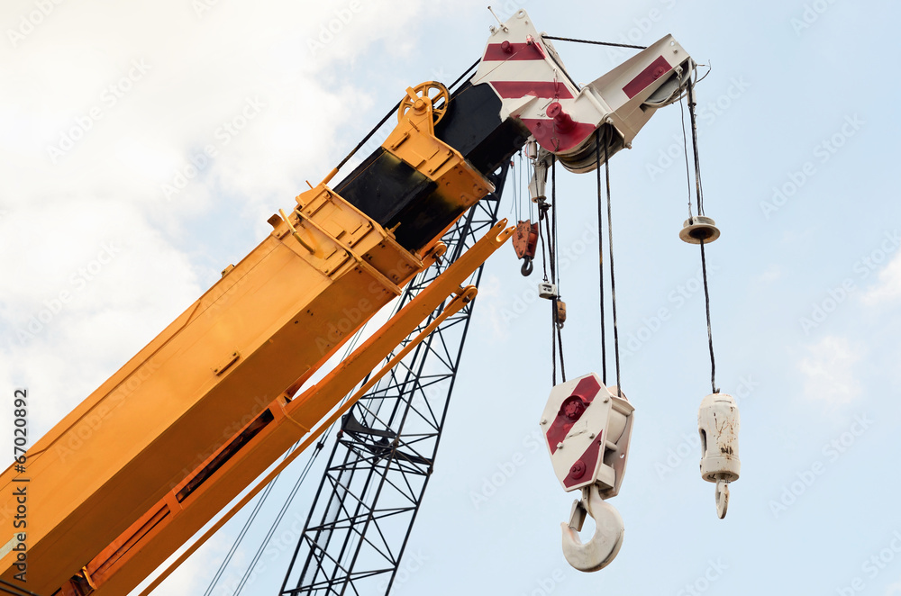 Fototapeta premium Crane at construction site against blue sky