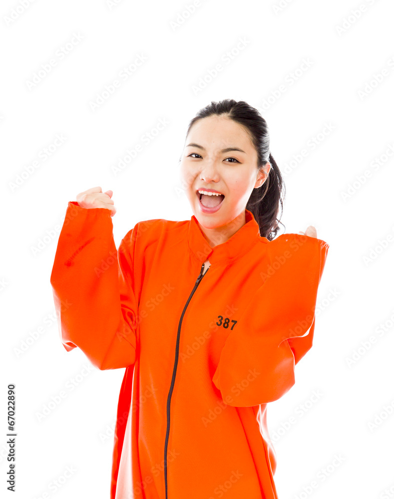 Young Asian woman celebrating success in prisoners uniform Young Asian woman celebrating success in prisoners uniform