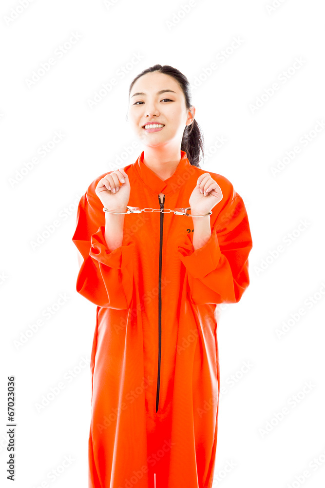 Handcuffed Asian young woman smiling in prisoners uniform