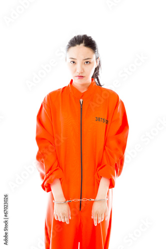 Handcuffed Asian young woman in prisoners uniform