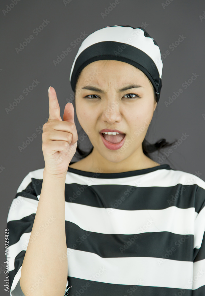 Upset young Asian woman scolding somebody in prisoners uniform Upset young Asian woman scolding somebody in prisoners uniform