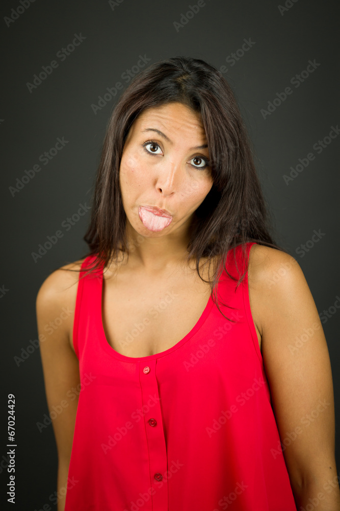 Portrait of a young woman sticking out her tongue Portrait of a young woman sticking out her tongue