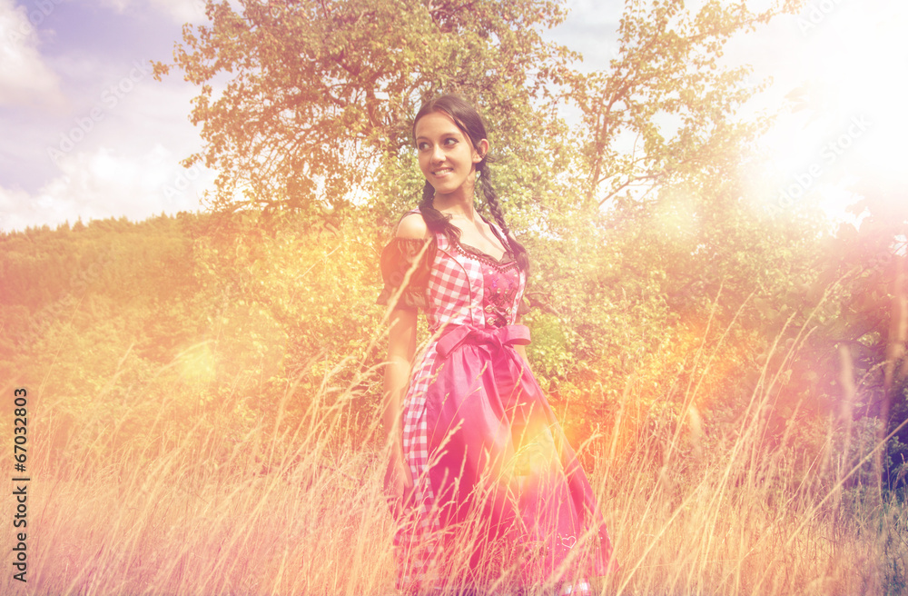 Young woman in dirndl walking alone in the field