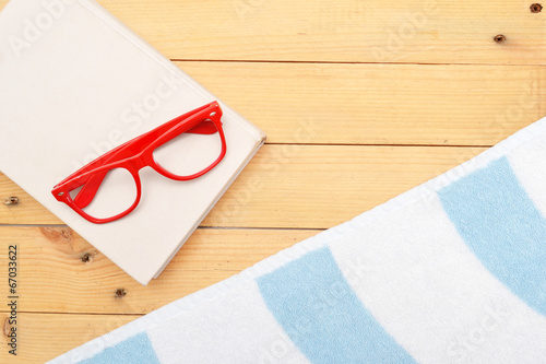 Book, glasses and beach towel