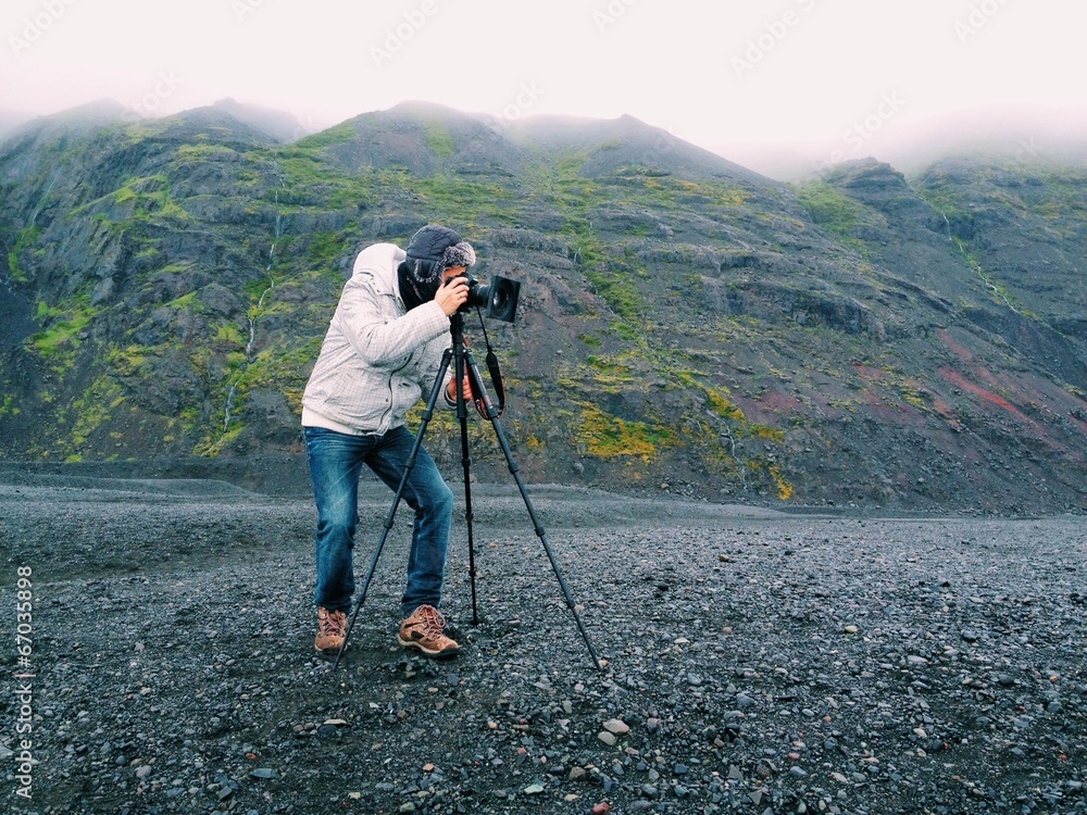 Photographer with a tripod, in the mountains of Iceland