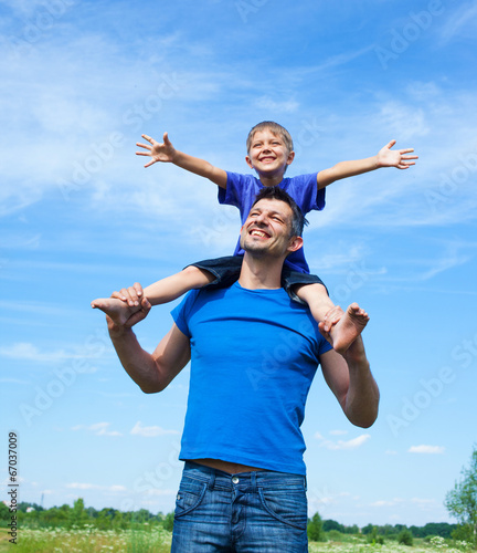 Happy father with son outdoors against sky