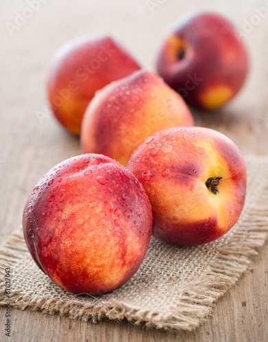 Juicy fresh peaches on wooden background