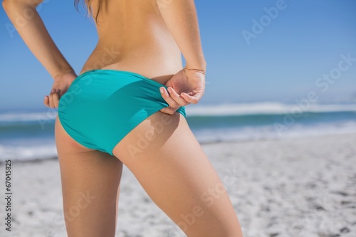 Mid section of fit woman in bikini on the beach