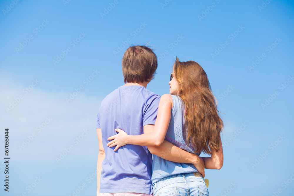 back view of couple hugging outdoors at beach back view of couple hugging outdoors at beach