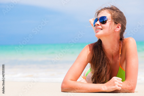 long haired young woman with flower in hair in bikini and