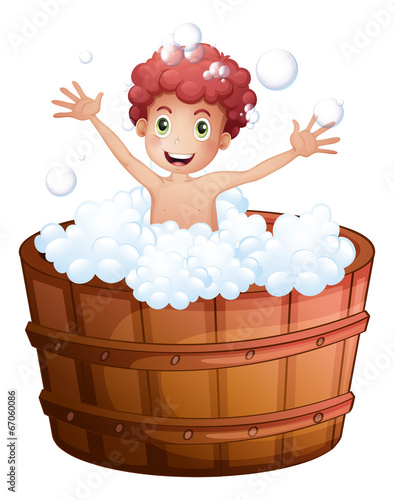 A young boy playing at the bathtub